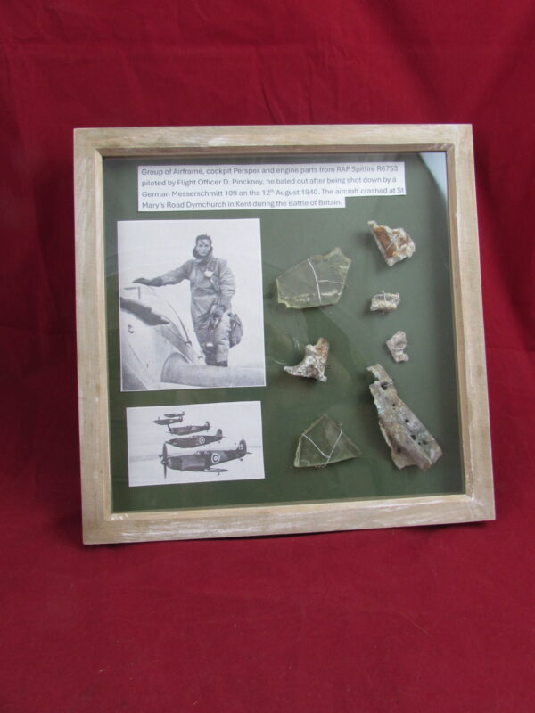 Large glass framed group of airframe, cockpit perspex and engine parts from RAF Spitfire R6753 piloted by Flight Officer D. Pinckney